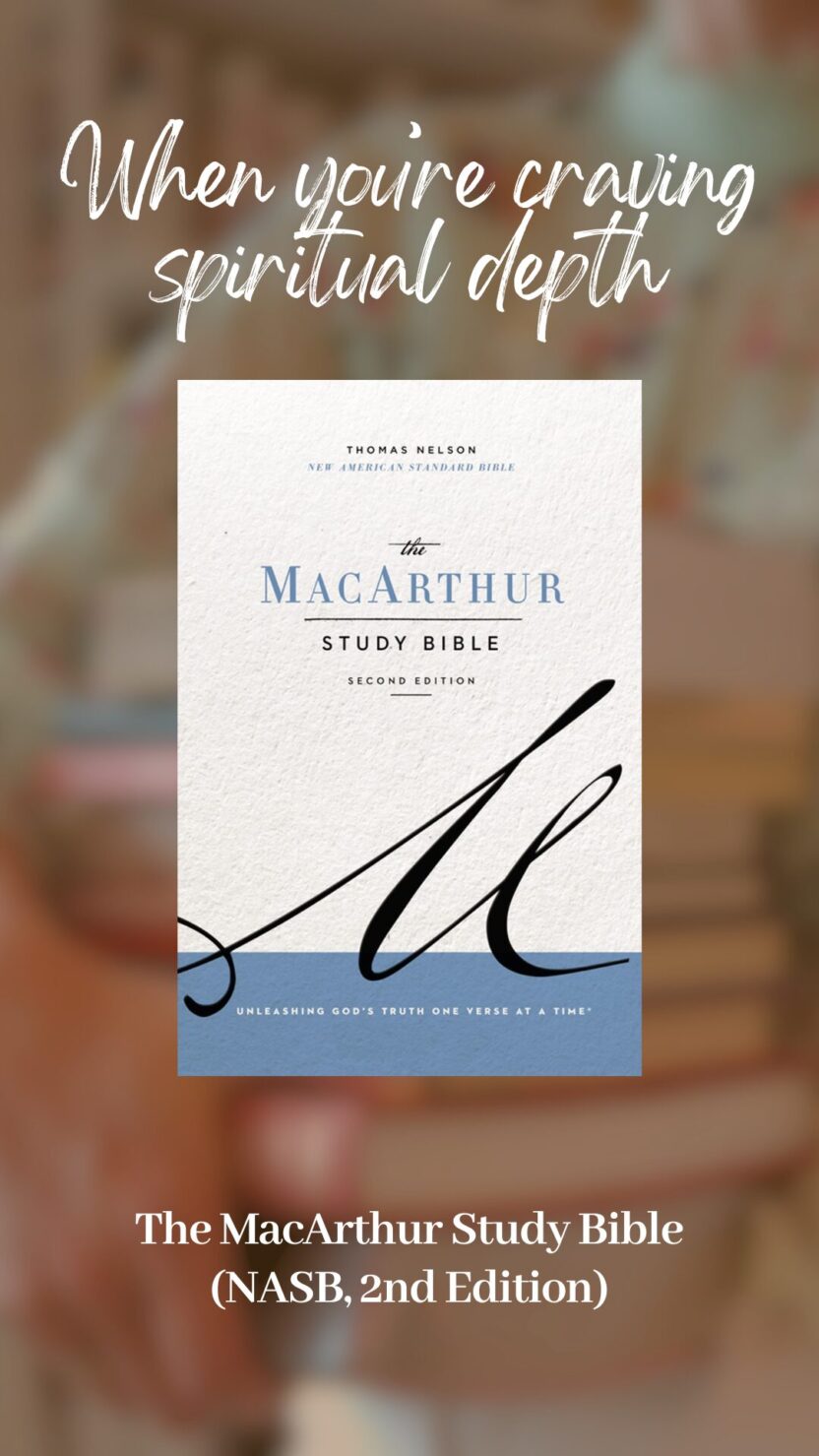 Man in swim trunks holds a baby in a blue life jacket in shallow water.