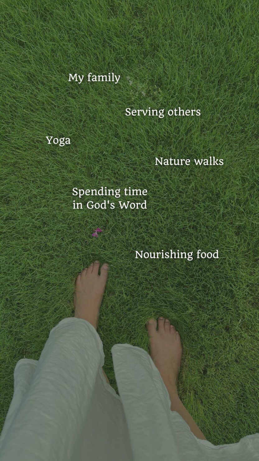 Man in swim trunks holds a baby in a blue life jacket in shallow water.