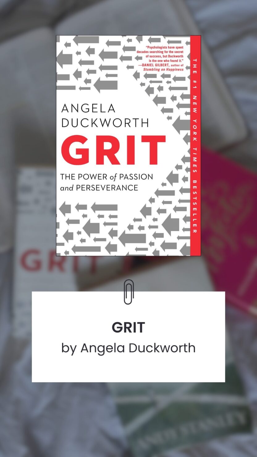 Man in swim trunks holds a baby in a blue life jacket in shallow water.