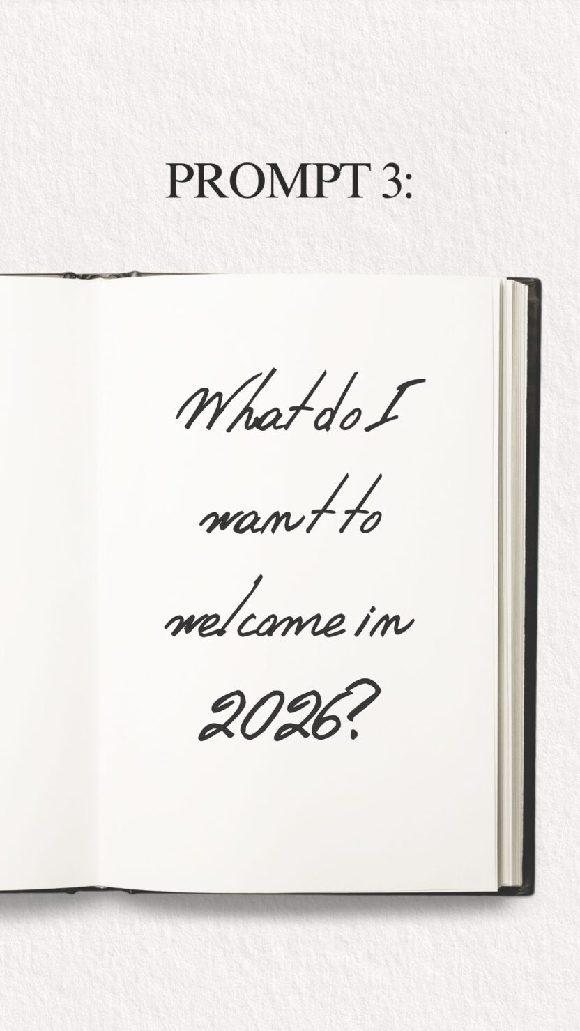 Man in swim trunks holds a baby in a blue life jacket in shallow water.