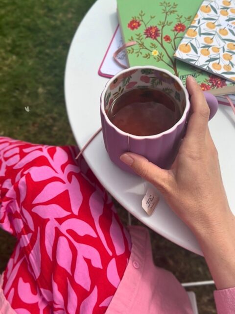 journals, a cup of tea, a girl writing outside